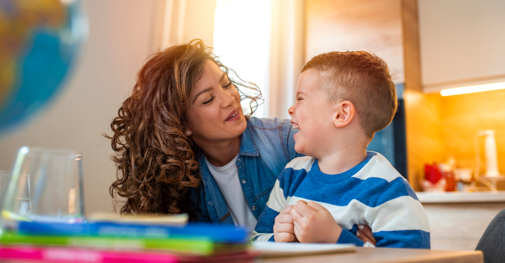 Latina mother looking at her 3 year old son smiling and laughing