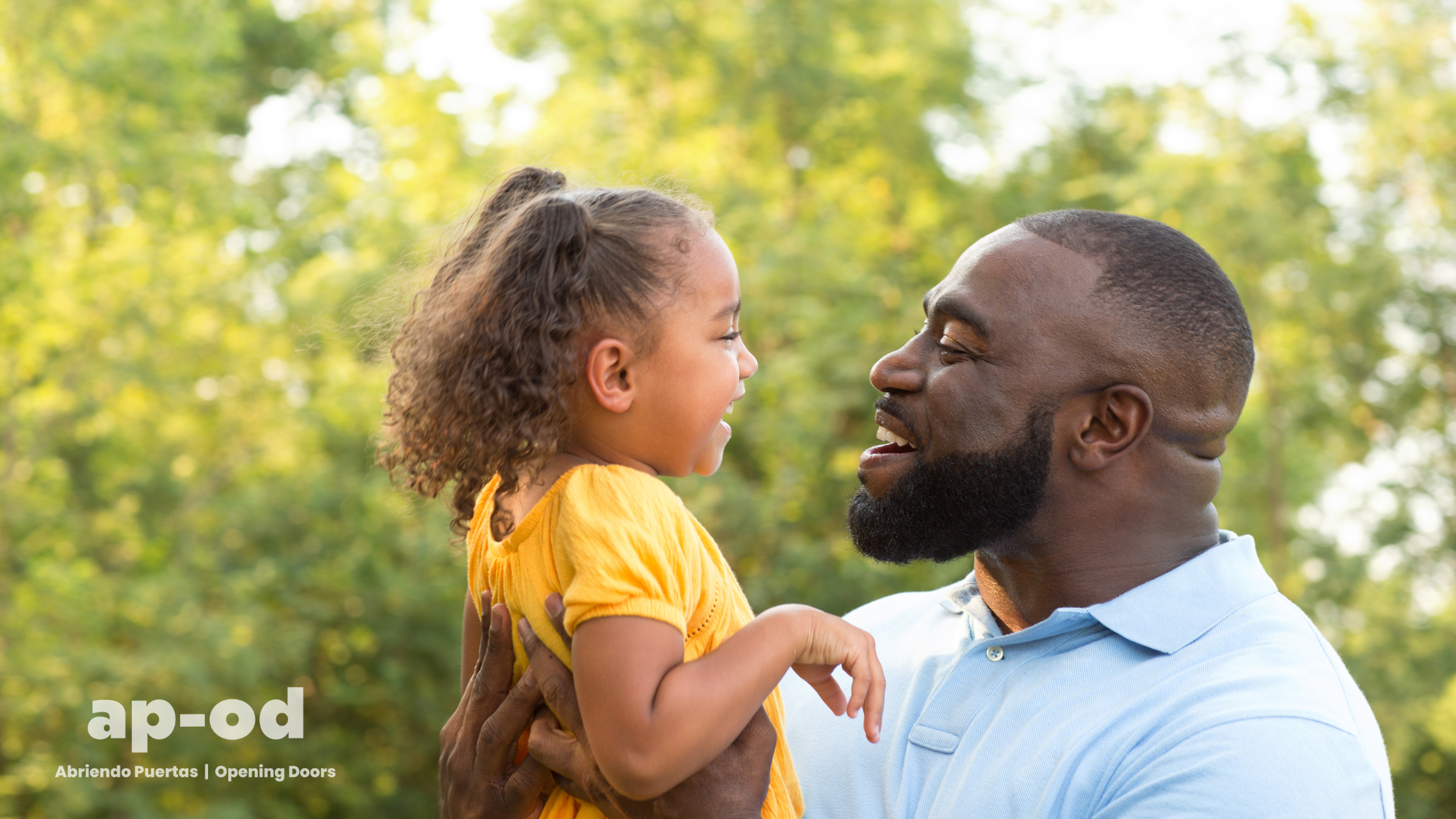 Father and daughter smiling at each other.